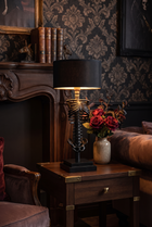 NecroLuxe Gothic Skeleton Table Lamp - lit on side table in dark elegant living room